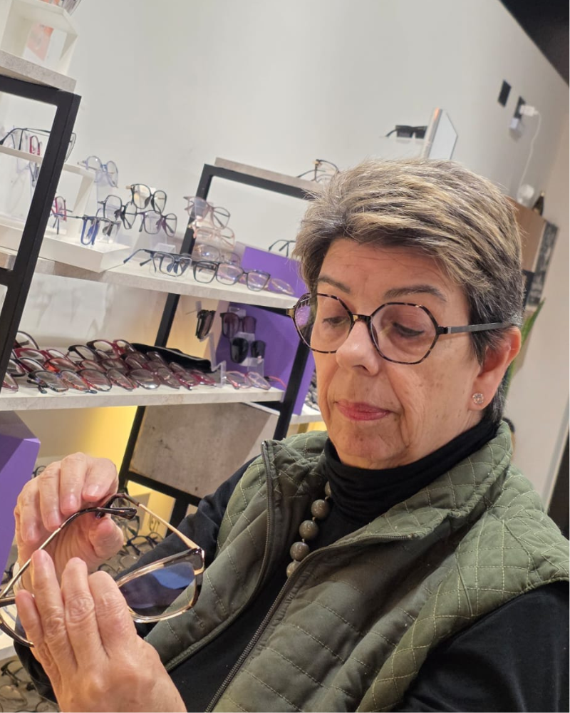 Regina, fundadora do Atelier do Óculos, dentro da loja